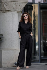 a lady in a black shirt and a pair of black pants